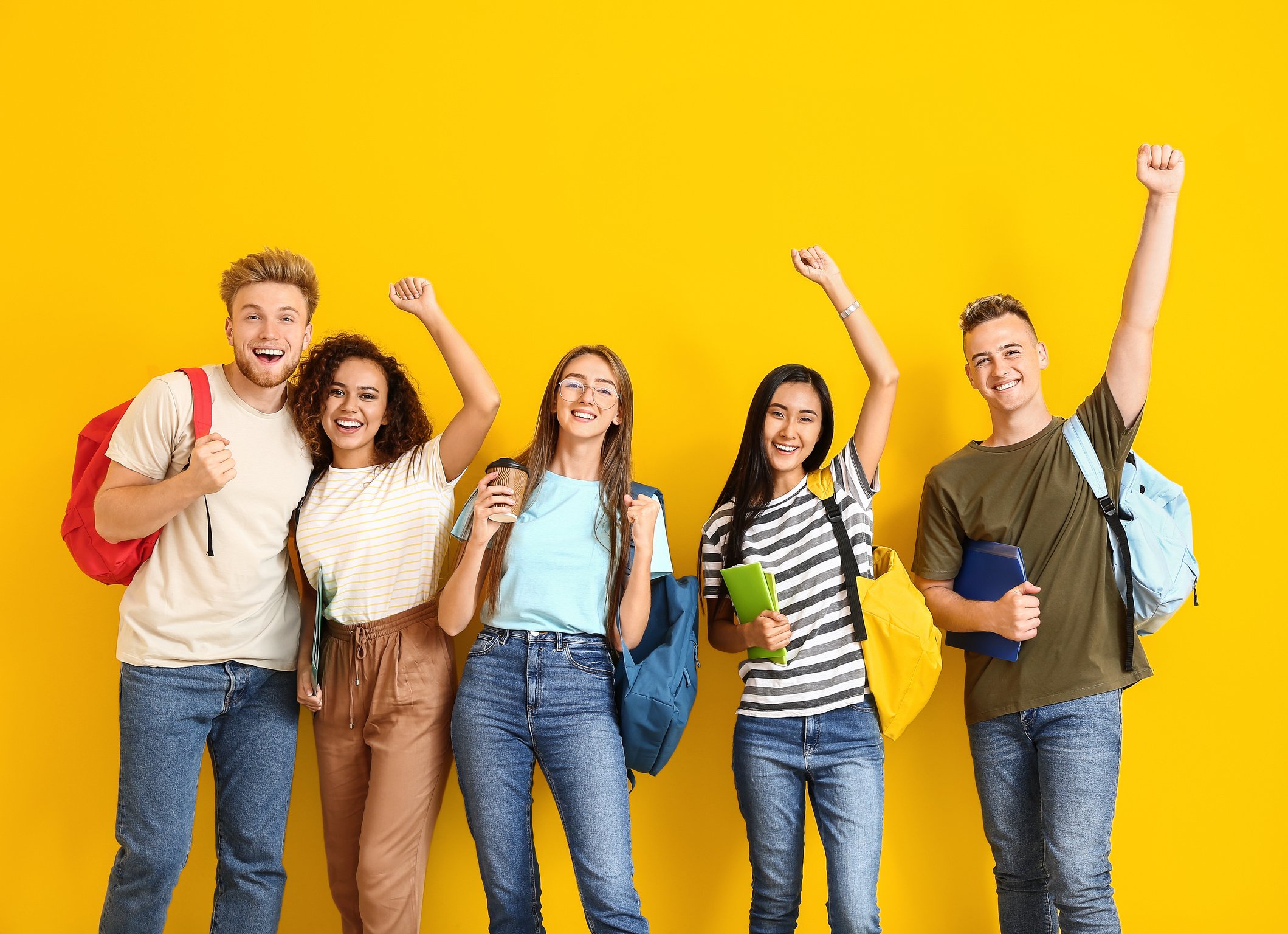 Group of Happy Students on Yellow Background